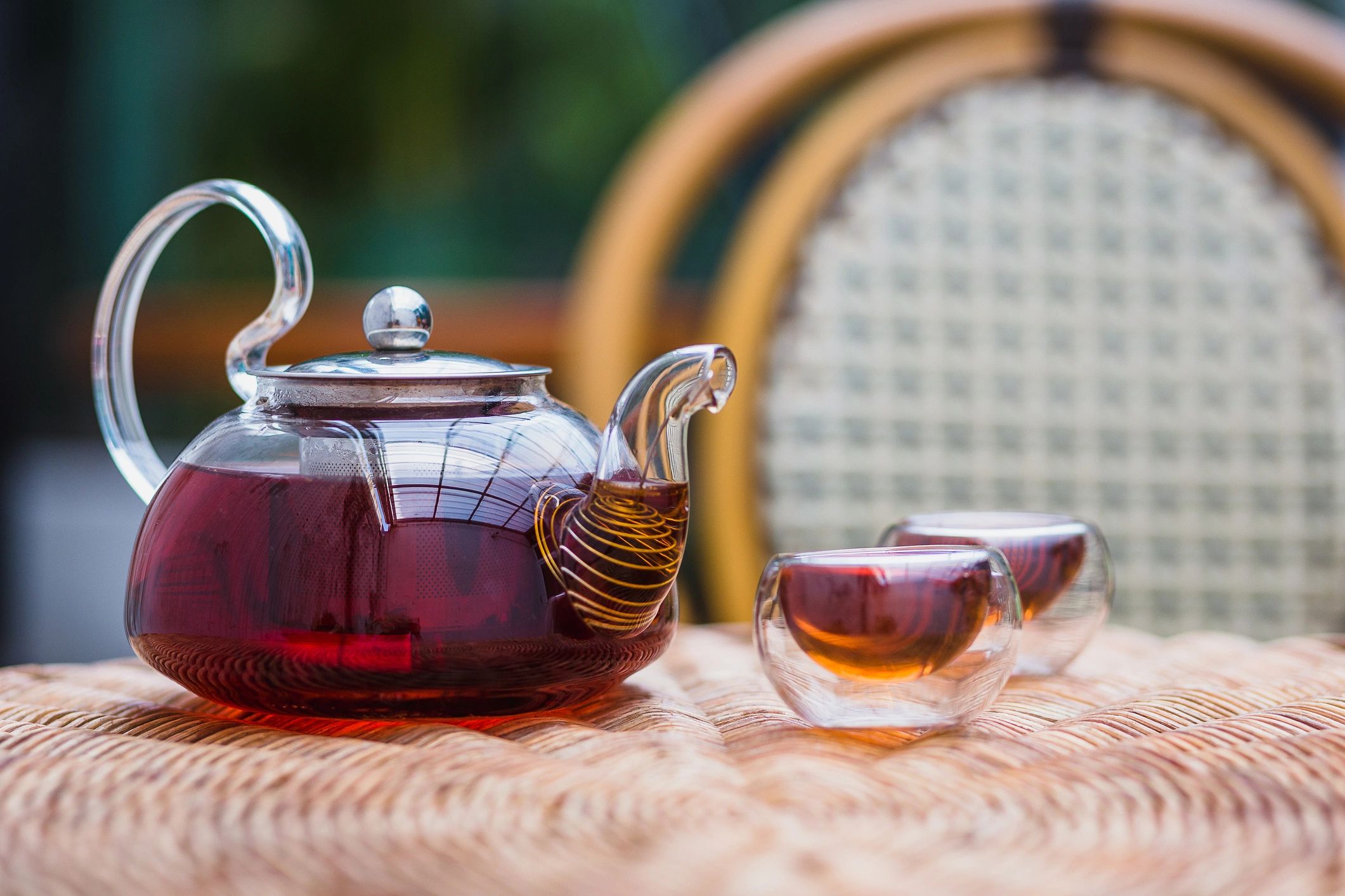 Glass teapot and tea cups set on a table