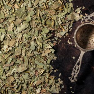 Eucalyptus leaves dried for herbal tea infusion on dark wood
