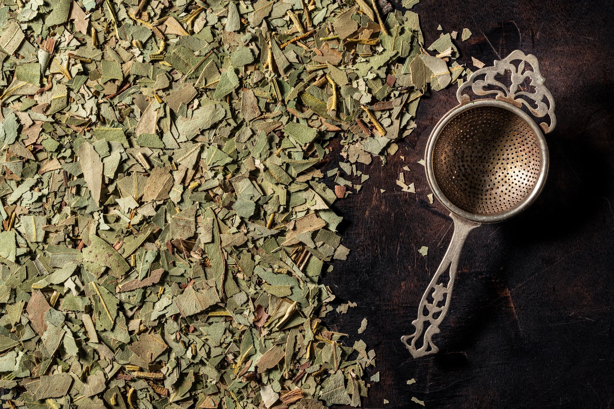 Dried herbal leaves on dark wood background