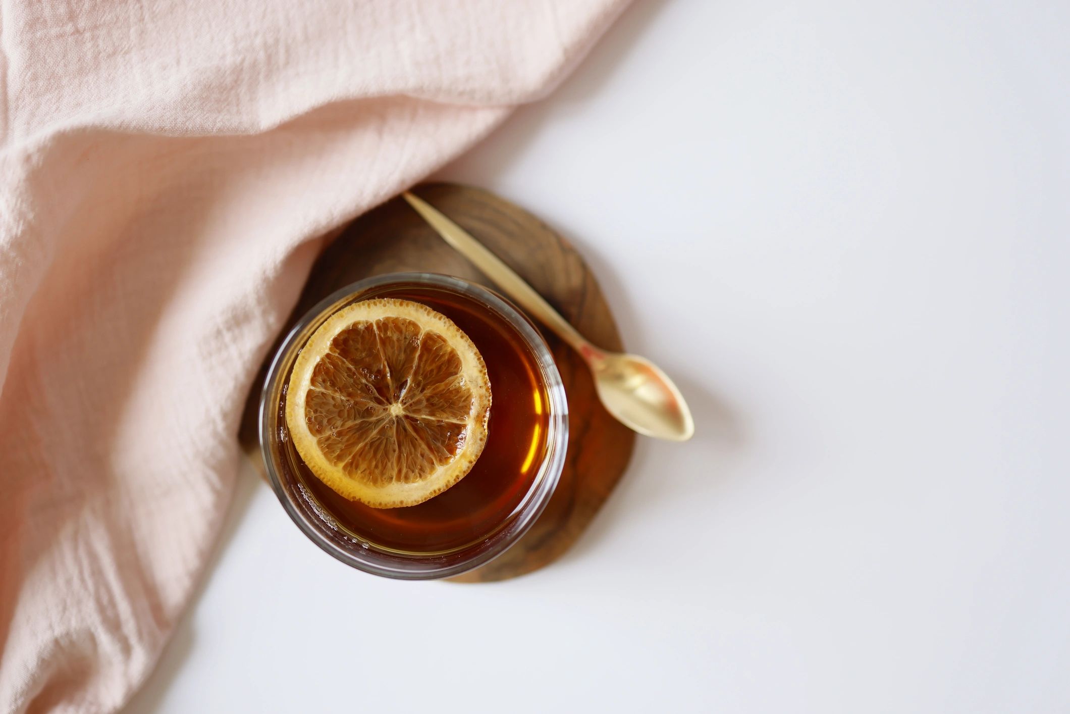 Glass of tea with dried orange slices on a coaster